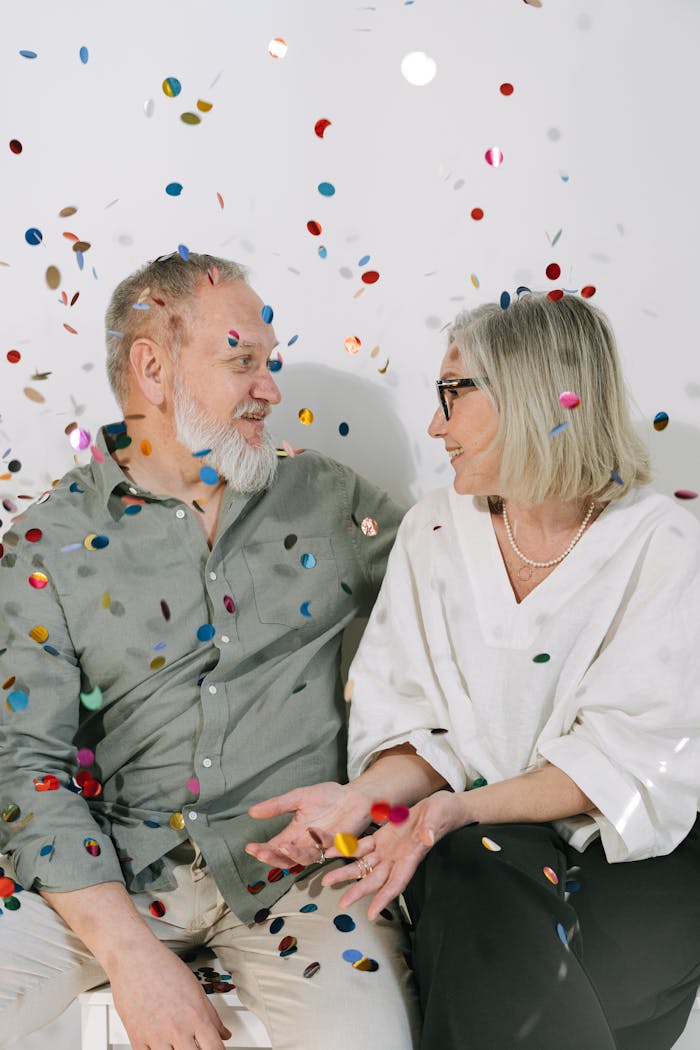 portfolio-img-02 Happy senior couple celebrating an anniversary with confetti indoors.